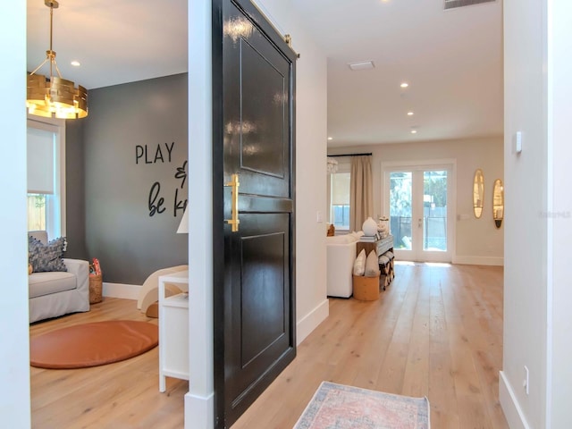 corridor featuring light hardwood / wood-style flooring and french doors