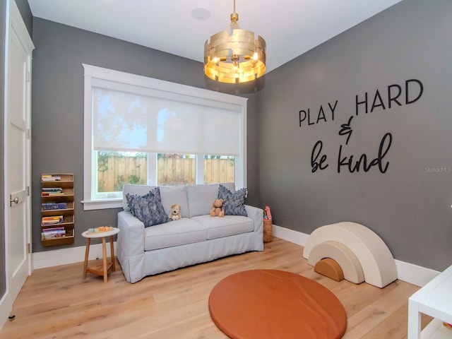 living area with light hardwood / wood-style flooring and an inviting chandelier