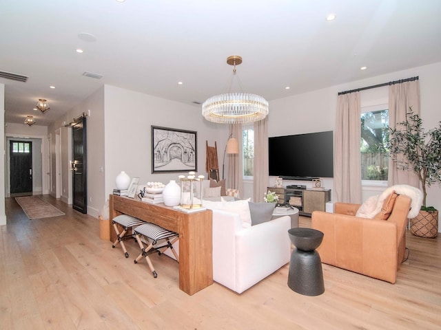 living room with light hardwood / wood-style flooring and a notable chandelier