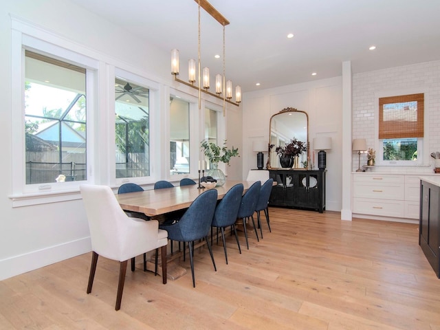 dining space featuring plenty of natural light, an inviting chandelier, and light wood-type flooring