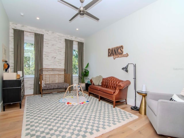 living area featuring ceiling fan, light wood-type flooring, and a wealth of natural light