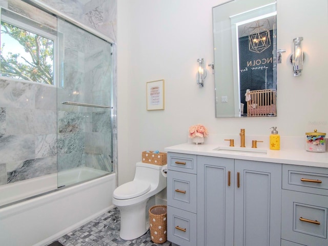 full bathroom featuring combined bath / shower with glass door, vanity, and toilet