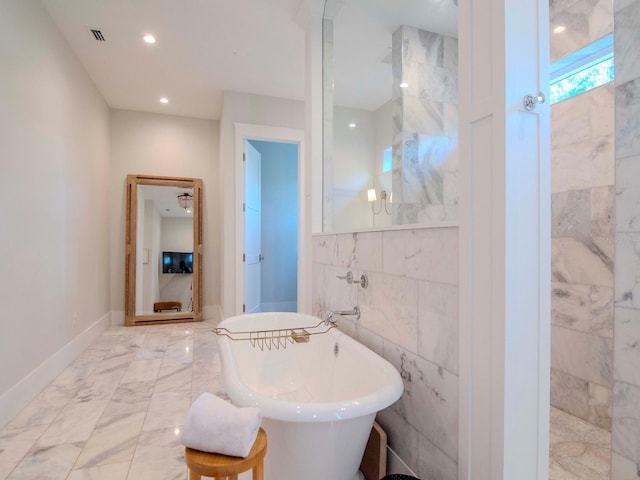 bathroom with tile walls and separate shower and tub