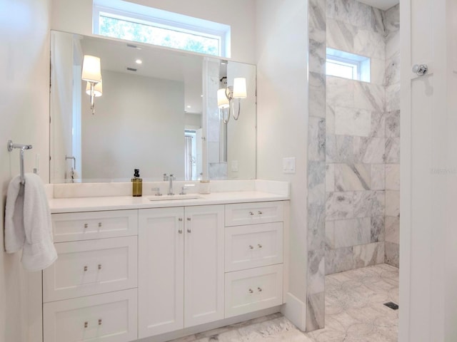 bathroom featuring tiled shower and vanity