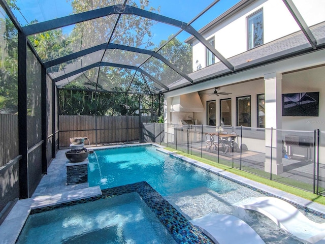 view of pool featuring a lanai, ceiling fan, pool water feature, and an in ground hot tub