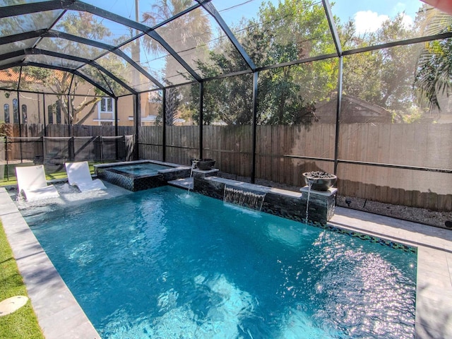 view of pool featuring pool water feature, glass enclosure, a patio area, and an in ground hot tub