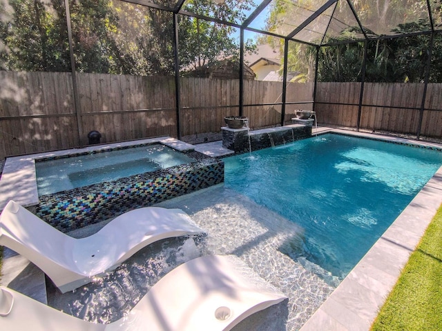 view of swimming pool with an in ground hot tub, glass enclosure, and pool water feature