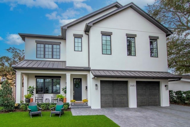 modern farmhouse style home featuring a front yard, a porch, and a garage