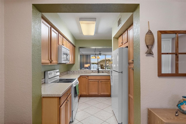 kitchen with sink, white appliances, and light tile patterned floors