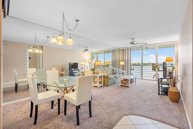 dining area featuring floor to ceiling windows, ceiling fan with notable chandelier, and carpet flooring