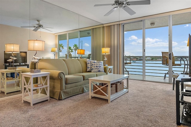 living room with plenty of natural light, a wall of windows, carpet flooring, and a water view