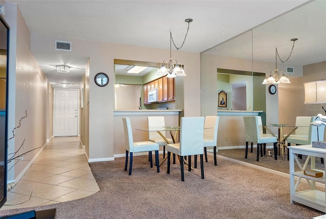 dining area featuring light tile patterned floors and a notable chandelier