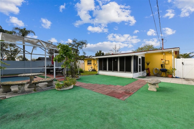 back of house with a pool, a lanai, a yard, and a patio area