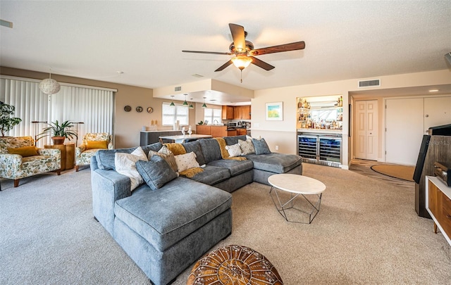 living room featuring a textured ceiling, ceiling fan, and light carpet