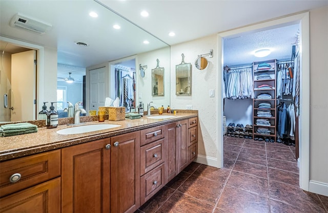 bathroom with vanity, a textured ceiling, ceiling fan, and a wall mounted air conditioner