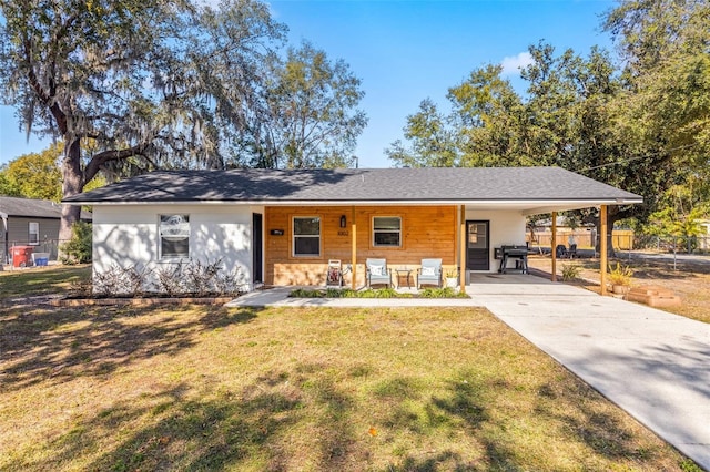 ranch-style home featuring a carport and a front lawn