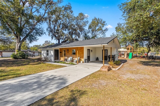 view of front of home featuring a playground, a carport, and a front yard