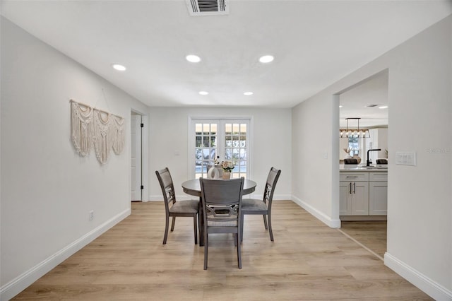 dining room featuring french doors and light wood-type flooring