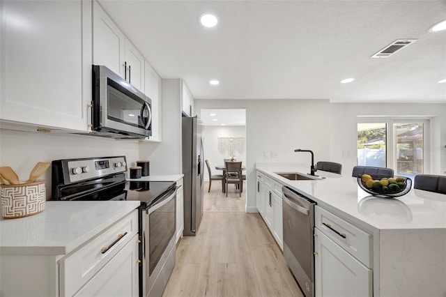 kitchen featuring stainless steel appliances, white cabinets, and sink