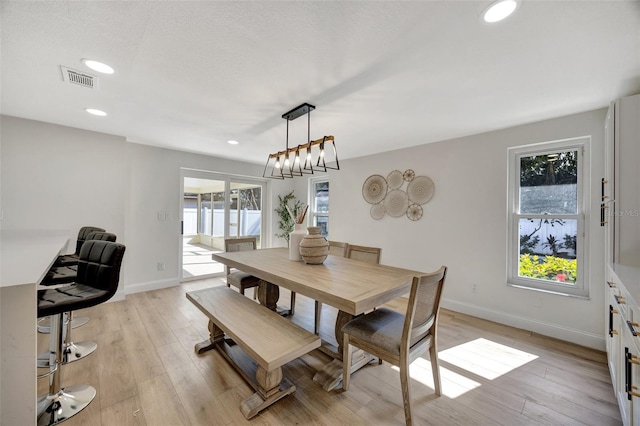 dining area featuring light hardwood / wood-style flooring and an inviting chandelier