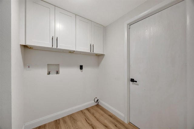 washroom featuring hookup for a washing machine, cabinets, and light hardwood / wood-style flooring