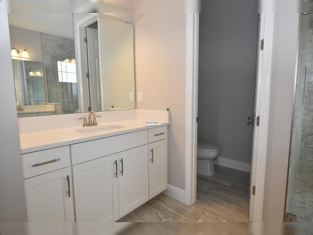 bathroom featuring an enclosed shower, vanity, and toilet