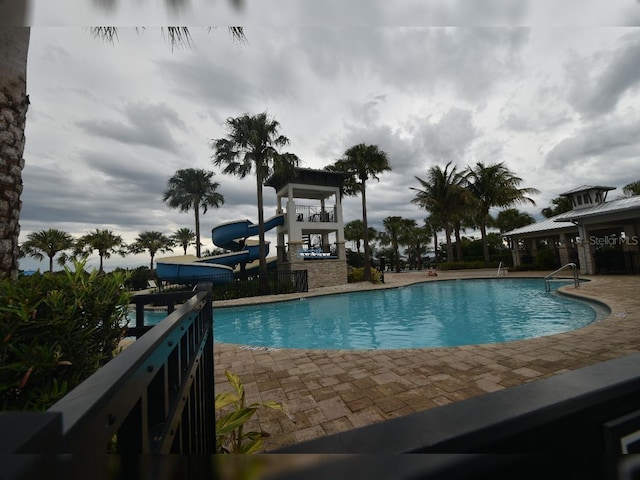 view of swimming pool featuring a water slide and a playground