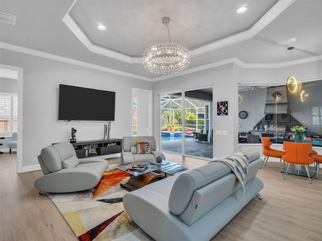 living room with a tray ceiling, crown molding, and a healthy amount of sunlight