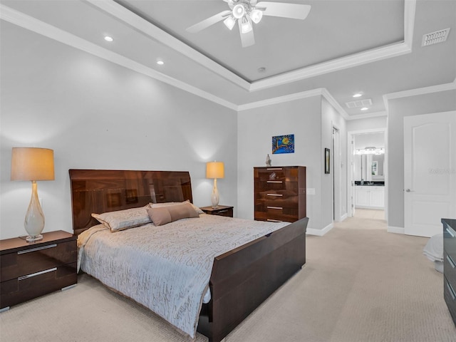 bedroom with ceiling fan, ensuite bathroom, light colored carpet, a tray ceiling, and ornamental molding