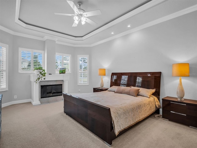 bedroom featuring ceiling fan, ornamental molding, and a tray ceiling