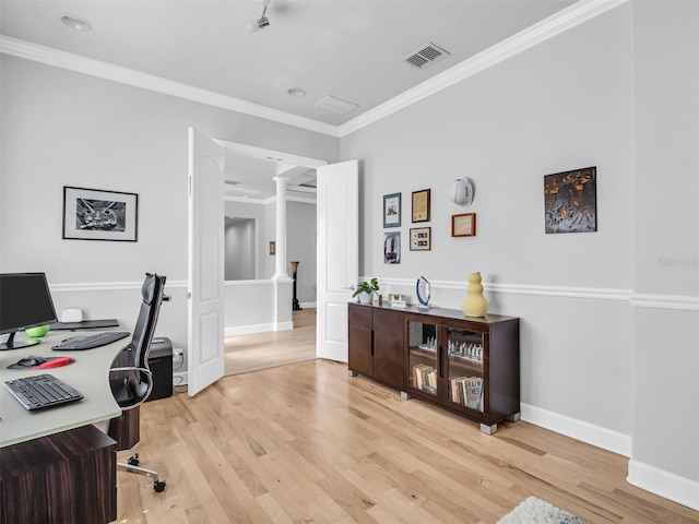 office space featuring decorative columns, crown molding, and light hardwood / wood-style floors