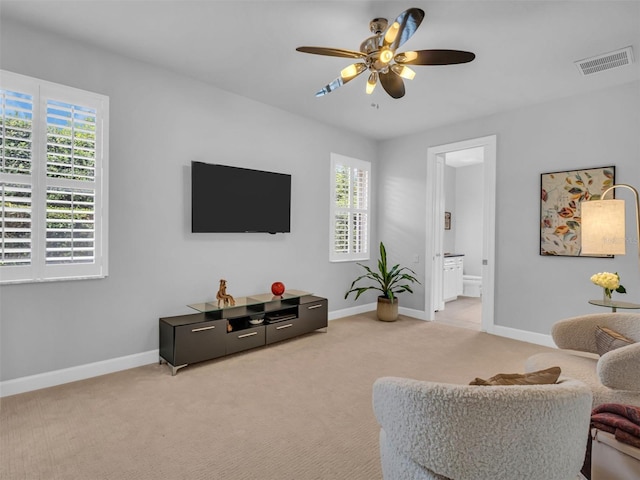 carpeted living room featuring plenty of natural light and ceiling fan