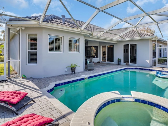 view of pool with an in ground hot tub, a lanai, and a patio area