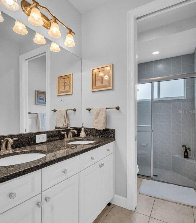 bathroom featuring tile patterned floors, an enclosed shower, vanity, and toilet