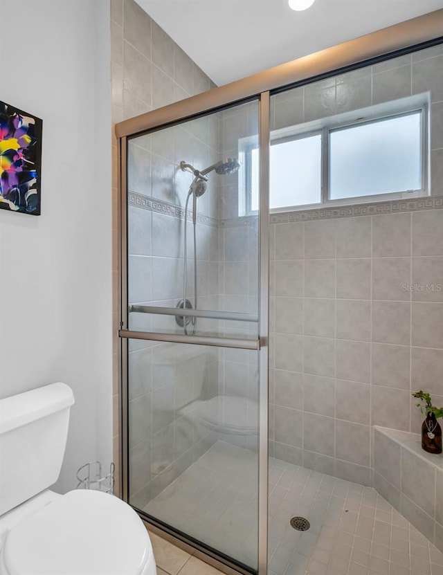 bathroom with toilet, an enclosed shower, and tile patterned floors