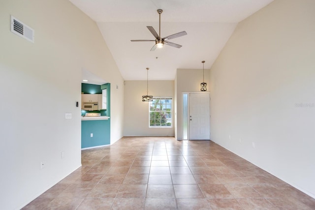 tiled spare room with ceiling fan and high vaulted ceiling