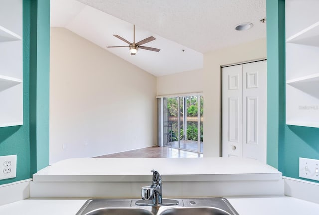 clothes washing area with ceiling fan, sink, and a textured ceiling