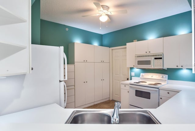 kitchen featuring white appliances, a textured ceiling, white cabinetry, sink, and ceiling fan