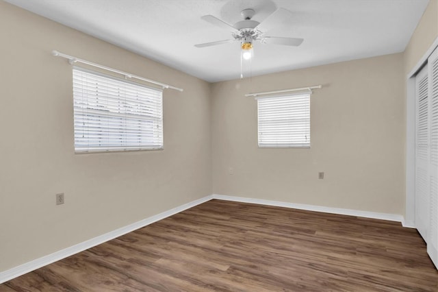 unfurnished bedroom featuring ceiling fan, a closet, and dark hardwood / wood-style flooring