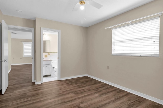 unfurnished bedroom with ceiling fan, dark hardwood / wood-style floors, and ensuite bath