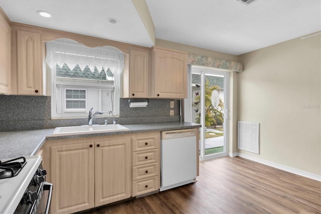 kitchen featuring dark hardwood / wood-style floors, backsplash, light brown cabinetry, dishwasher, and sink