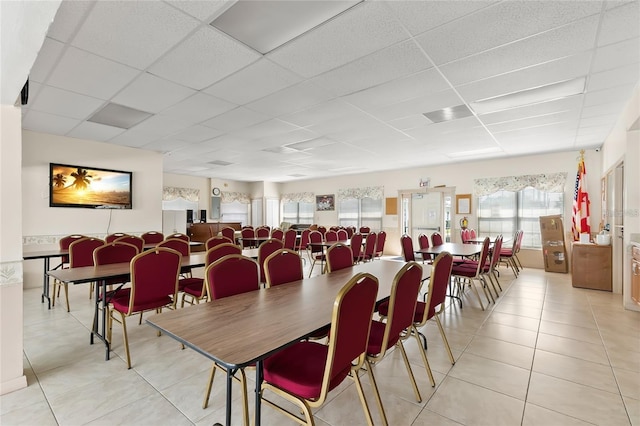 dining area featuring light tile patterned flooring and a drop ceiling