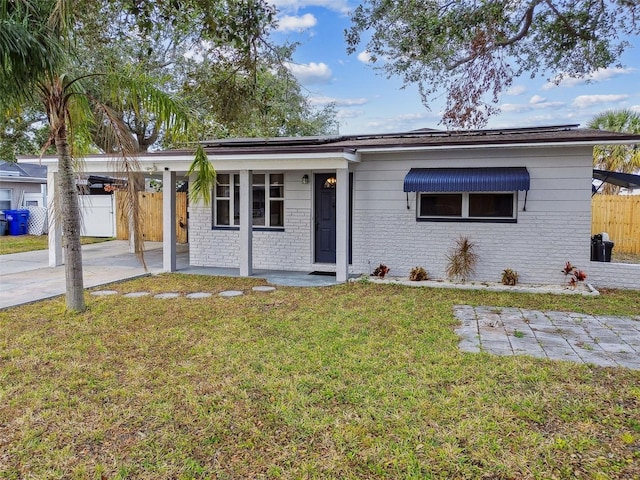 ranch-style home featuring solar panels and a front yard