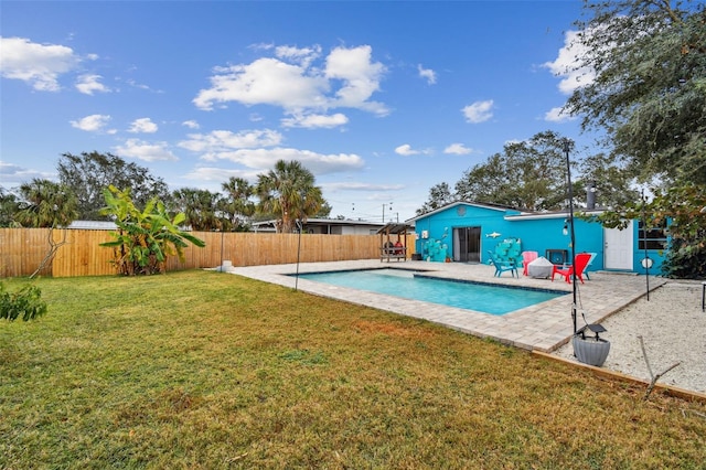 view of pool with a patio area and a yard