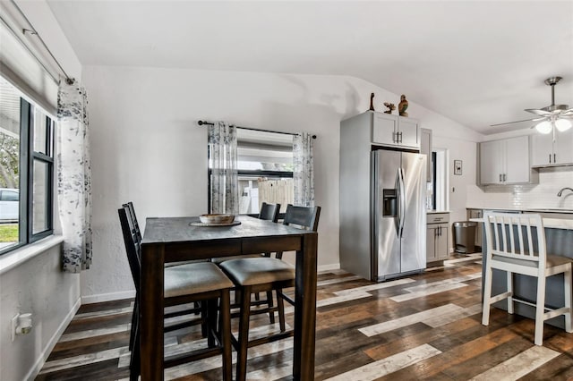 dining room with sink, ceiling fan, vaulted ceiling, and dark hardwood / wood-style floors