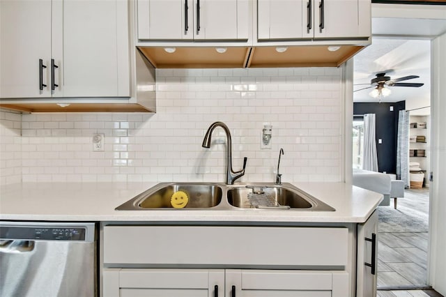 kitchen with sink, white cabinetry, ceiling fan, stainless steel dishwasher, and decorative backsplash