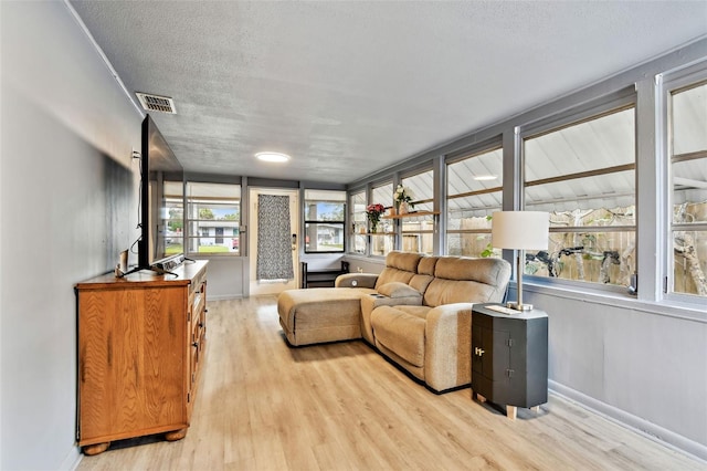 living room featuring a textured ceiling and light wood-type flooring