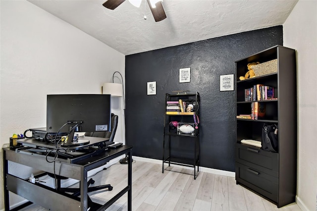 office space with ceiling fan, light hardwood / wood-style flooring, vaulted ceiling, and a textured ceiling