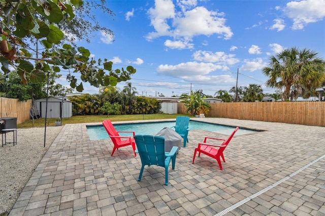 view of swimming pool featuring a storage unit and a patio area