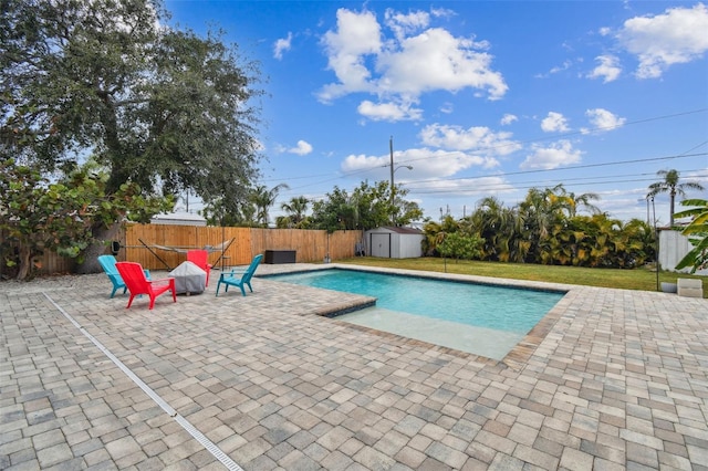 view of swimming pool with a shed and a patio area